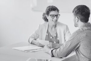 Woman interviewing man during recruitment process outsourcing