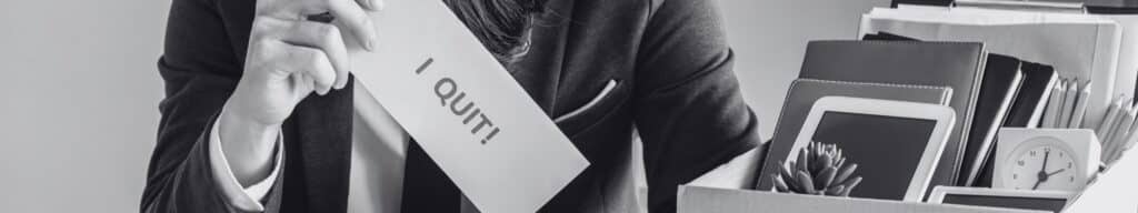 Hand holding "I Quit" sign after first year employee attrition