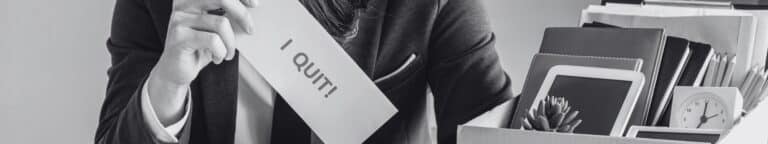 Hand holding "I Quit" sign after first year employee attrition