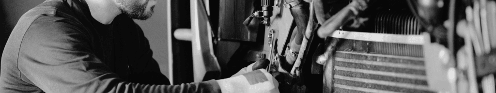 Maintenance technician from hiring pipeline turning wrench on a bolt on a machine
