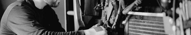 Maintenance technician from hiring pipeline turning wrench on a bolt on a machine
