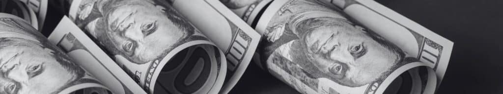 Rolled of dollar bills representing the costs of recurring hiring