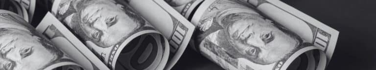 Rolled of dollar bills representing the costs of recurring hiring